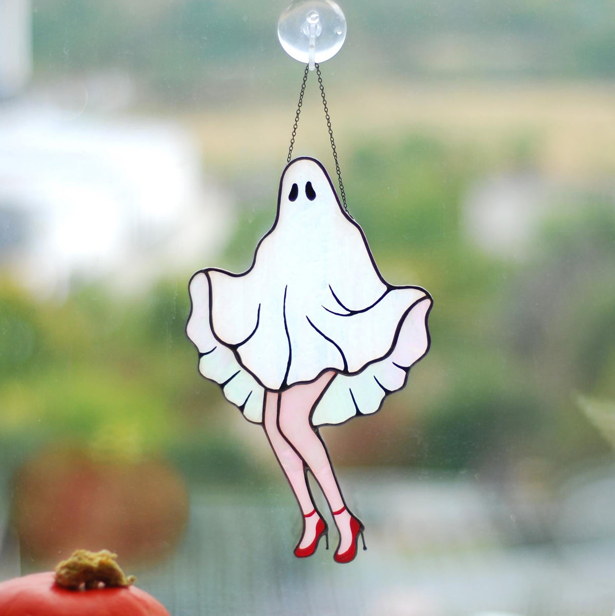 Handmade stained glass ghost suncatcher with red heels hanging in a sunny window, Tiffany copper foil technique