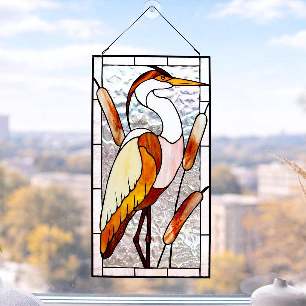 Handmade stained glass heron panel with reeds, hanging in a sunny window, Tiffany copper foil technique