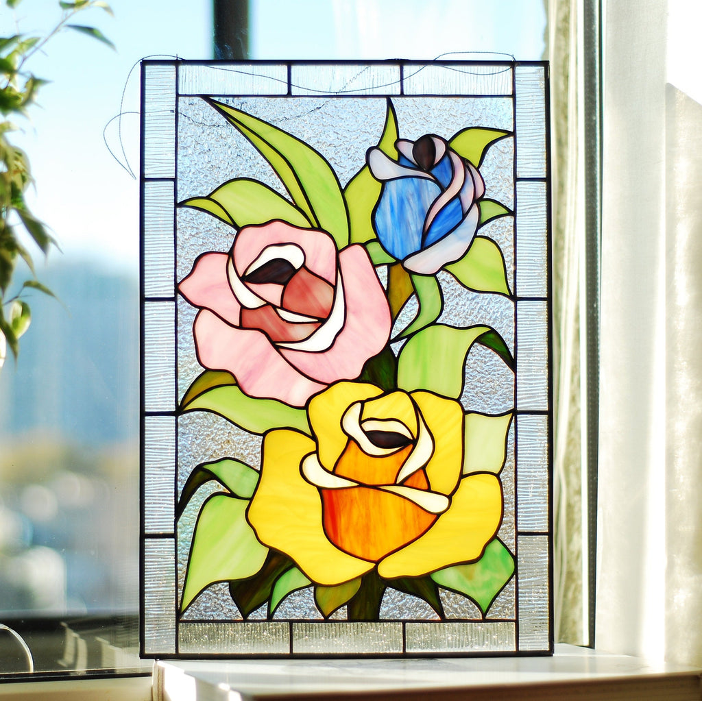 Handmade stained glass multicolored roses panel hanging in a sunny window, Tiffany copper foil technique