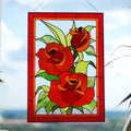 Handmade stained glass red rose panel with three roses and green leaves, hanging outdoors, Tiffany copper foil technique