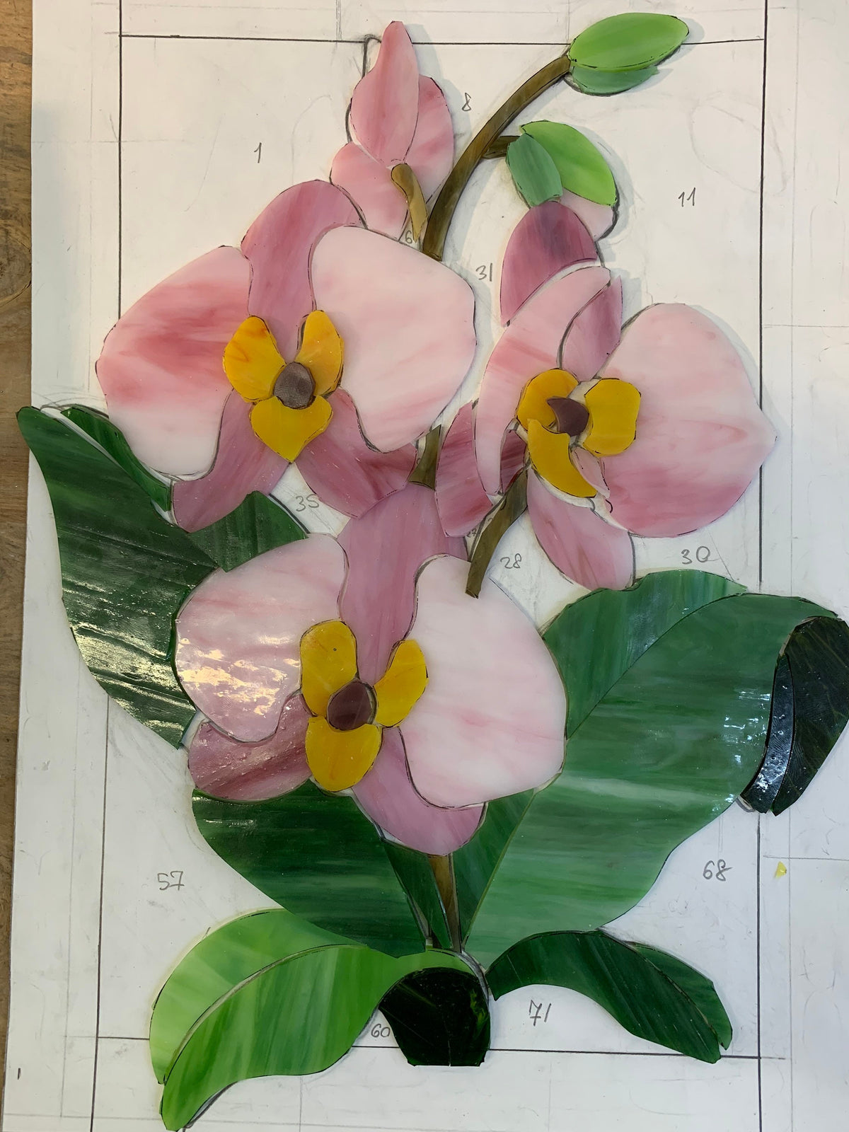 Stained glass orchid panel work in progress, pink glass pieces with copper foil technique, handmade floral window art process
