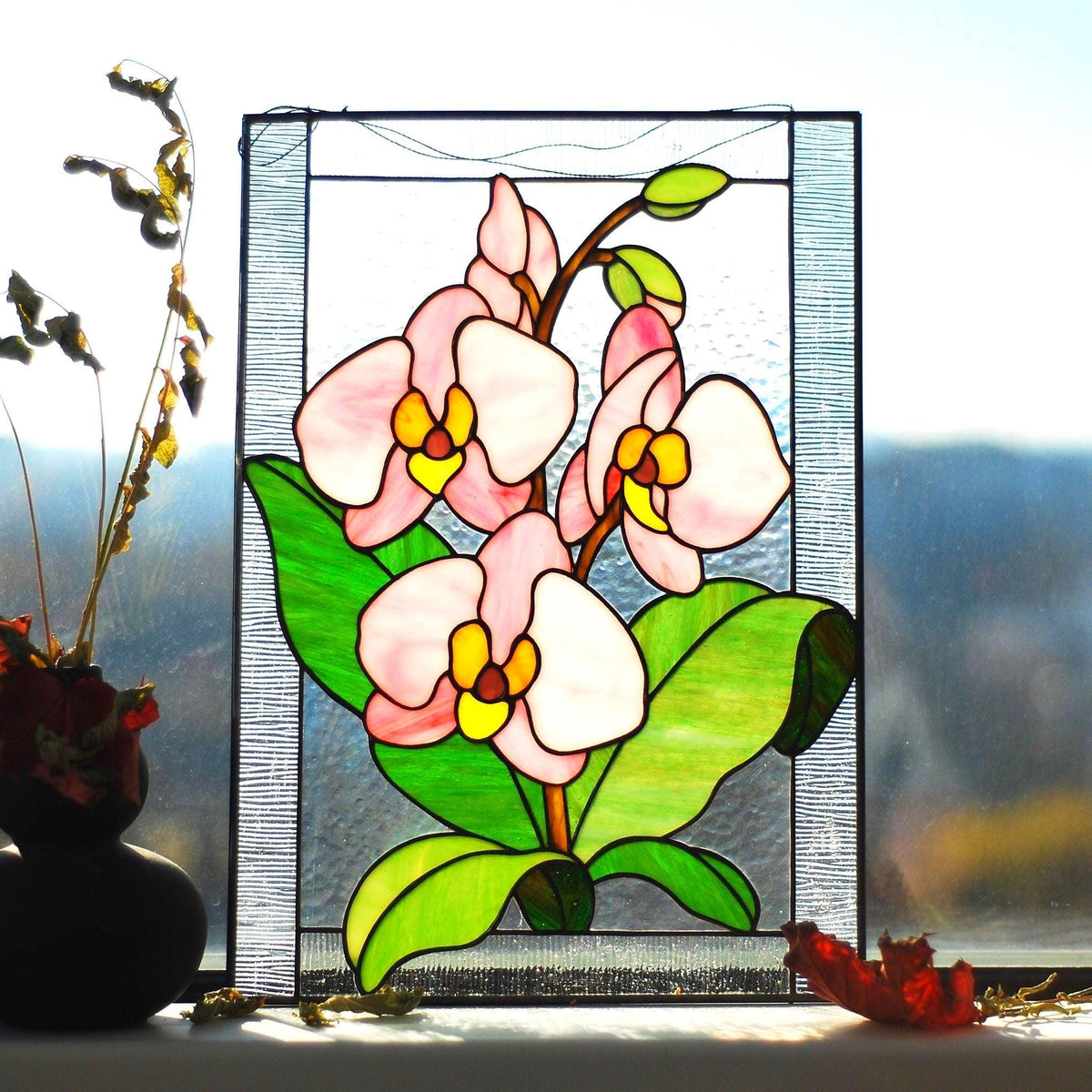 Handmade stained glass orchid panel on a windowsill with natural light, pink and white phalaenopsis orchids with green leaves, Tiffany copper foil, 16x12 inches
