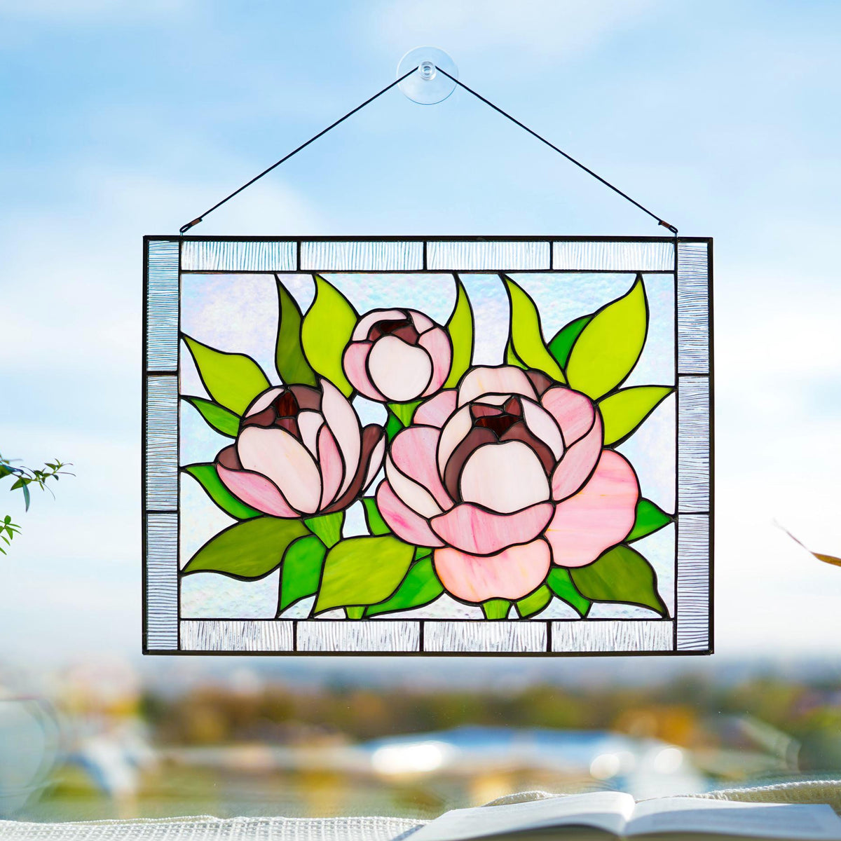 Handmade stained glass pink peony window hanging suspended in sunlit window, three blooms with green leaves, Tiffany copper foil art

