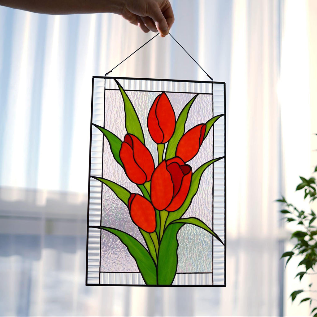 Stained glass red tulip floral panel held sideways showing zinc frame and copper foil detail, vivid red and green cathedral glass, handmade Ukraine
