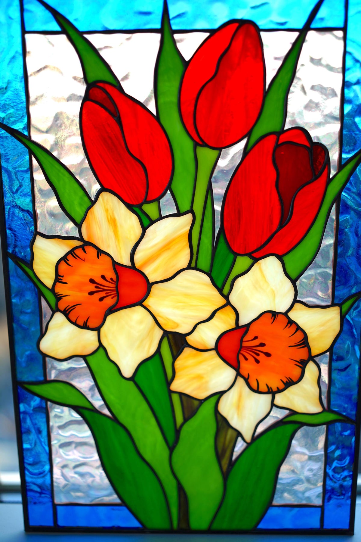 Handmade stained glass panel with red tulips and yellow daffodils, blue border frame, 16x10.6 inches